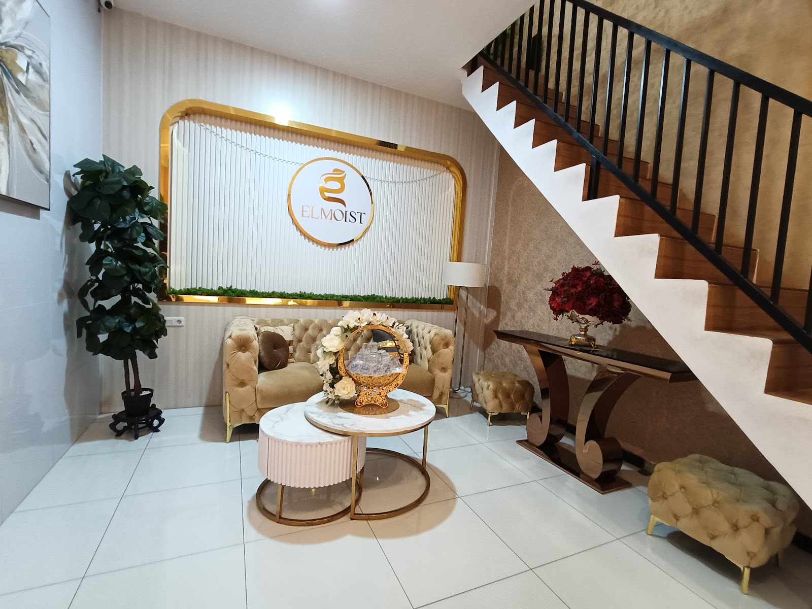 Elmoist Pasirian lobby with gold framed brand mirror and staircase